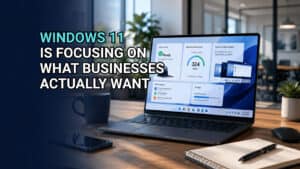 Laptop displaying network performance metrics on a modern office desk, highlighting Windows 11 focus for business solutions. Image text: Windows 11 Is Focusing on What Businesses Actually Want